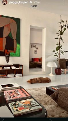 a living room filled with furniture and a painting on the wall