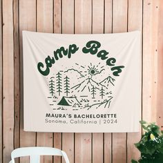 a wall hanging on the side of a wooden building with a sign that says camp bar maura's bachelor