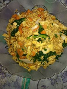 a bowl filled with rice and vegetables on top of a table