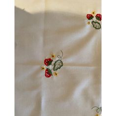 a white table cloth with strawberries and daisies on it