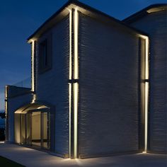 a modern house lit up at night with outdoor lighting