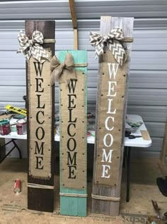 three wooden signs with bows on them that say welcome, welcome and welcome to us