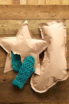 a stuffed star sitting on top of a pillow next to a pair of mittens