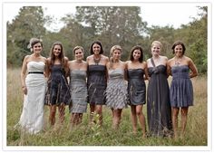 a group of women standing next to each other in front of some trees and grass