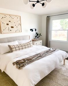 a white bed sitting in a bedroom next to a window