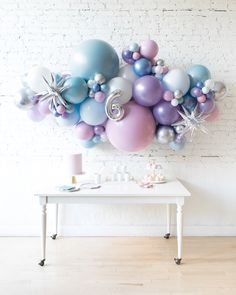 a white table topped with lots of balloons