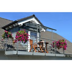 a balcony with flowers and chairs on it