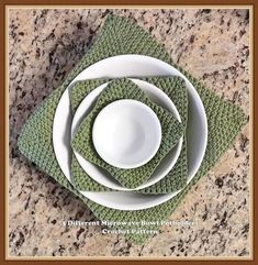 there is a white plate and green napkins on top of each other in the shape of a flower