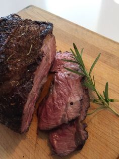 a piece of meat sitting on top of a wooden cutting board