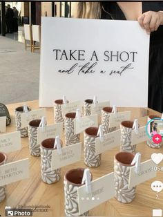 there are many small cups that have been placed on the table with name tags attached to them