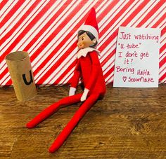 an elf is sitting on the floor next to a paper roll and a sign that says just watching u - tube i don't got it