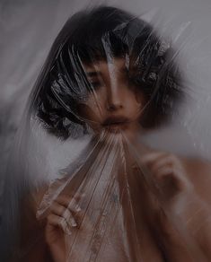 a woman hiding her face behind plastic bags