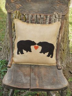 an old chair with two bears on it and a heart shaped pillow hanging from the back