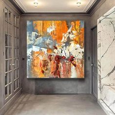 an abstract painting hangs on the wall in a hallway with marble walls and flooring