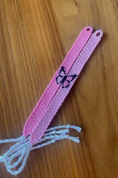 a pink piece of fabric with scissors on it sitting on top of a wooden table