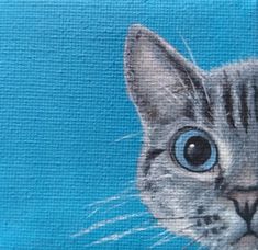 a painting of a grey cat with blue eyes on a blue background is shown in the foreground