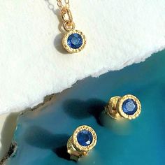 This Sapphire September Birthstone Jewellery Set features stud earrings and a matching pendant necklace with hand-faceted blue sapphires set into a gently textured 18kt gold plated Sterling Silver surrounds. The birthstone for September, this stunning jewellery set, with its deep azure hues is a wonderful alternative to more generic solitaire jewellery. Original, unique and truly captivating. These raw natural stones will come with internal imperfections which add to the uniqueness of the produc Blue Hammered Jewelry As A Gift, Blue Hammered Jewelry As Gift, Blue Hammered Jewelry For Gift, Gold Jewellery Set, September Birthstone Jewelry, Gold Jewelry Sets, Silver Jewellery Sets, Sterling Silver Jewellery, September Birthstone