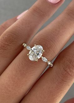 a woman's hand with a diamond ring on top of her finger and the bottom half