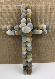 a cross made out of rocks sitting on top of a table