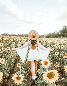 a woman standing in a field of sunflowers