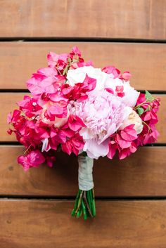 a bouquet of pink and white flowers sitting on top of a wooden table