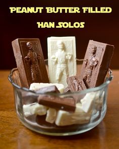 a glass bowl filled with assorted chocolates on top of a wooden table