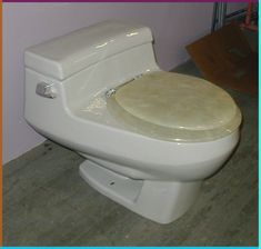 a white toilet sitting on top of a wooden floor