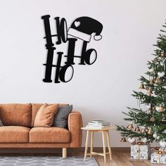 a living room with a couch, christmas tree and wall decoration in black on white