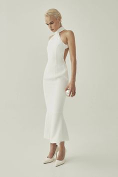 HALTER NECK MIDI DRESS, CRAFTED IN WHITE CREPE FABRIC, FEATURING AN OPEN BACK, AND A MERMAID SILHOUETTE. White Halter Neck Dress For Formal Occasions, White Halter Neck Formal Dress, White Backless Midi Dress For Wedding, Elegant White Halter Neck Midi Dress, White Halter Neck Midi Dress For Formal Occasions, Chic White Backless Dress, Halter Neck Midi Dress, Mermaid Silhouette, A Mermaid