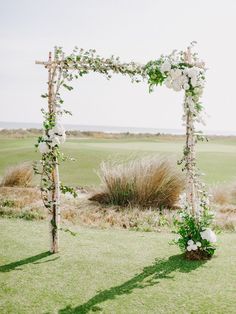 an outdoor ceremony setup with white flowers and greenery