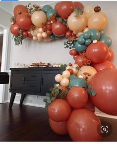 an arch made out of balloons in the shape of a letter o on a wooden floor