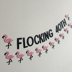 the flamingos are lined up on the wall to decorate their birthday party decorations with pink and black letters