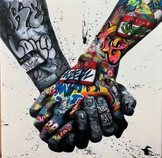 two hands holding each other with graffiti all over them