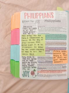 an open bible with colorful sticky notes attached to it and the words written in different languages