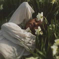 a woman is laying in the grass with flowers