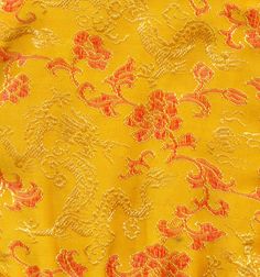 yellow and red fabric with an intricate design on it's side, close up