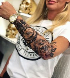 a woman with a tattoo on her arm and wrist is holding a clock in the shape of a rose