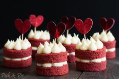 red velvet cupcakes with white frosting and hearts on top for valentine's day