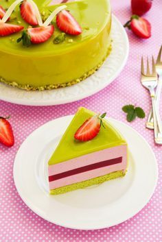 a piece of cake on a plate with strawberries and forks next to the cake