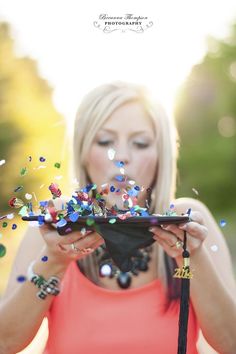 a woman holding a plate with confetti on it in front of her face