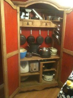 an open cabinet with pots and pans on it in a kitchen area that appears to be being used as a pantry