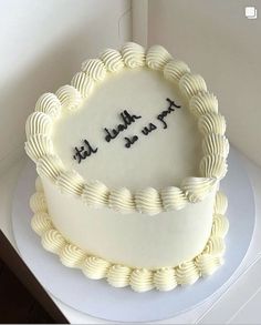 a white cake with writing on it sitting on top of a table