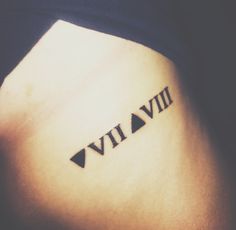 a tattoo with roman numerals on the back of a woman's stomach