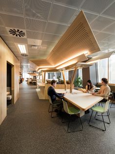 three people sitting at a table in an office