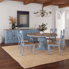 a dining room table with blue chairs and a chandelier hanging from the ceiling