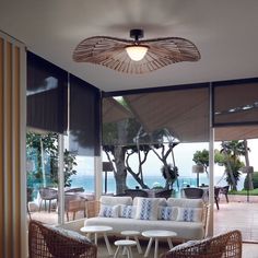 a living room with wicker furniture and an ocean view