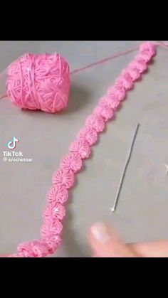 the yarn is pink and has been crocheted to look like it's being worked on