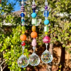 a wind chime hanging from a tree filled with lots of colorful beads and charms