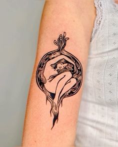 a woman's arm with a black and white tattoo design on the left forearm