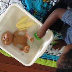 a baby in a bath tub with a toy banana